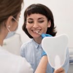 young-female-patient-looking-mirror-check-teeth-matching-before-dental-procedure_23-2148985749